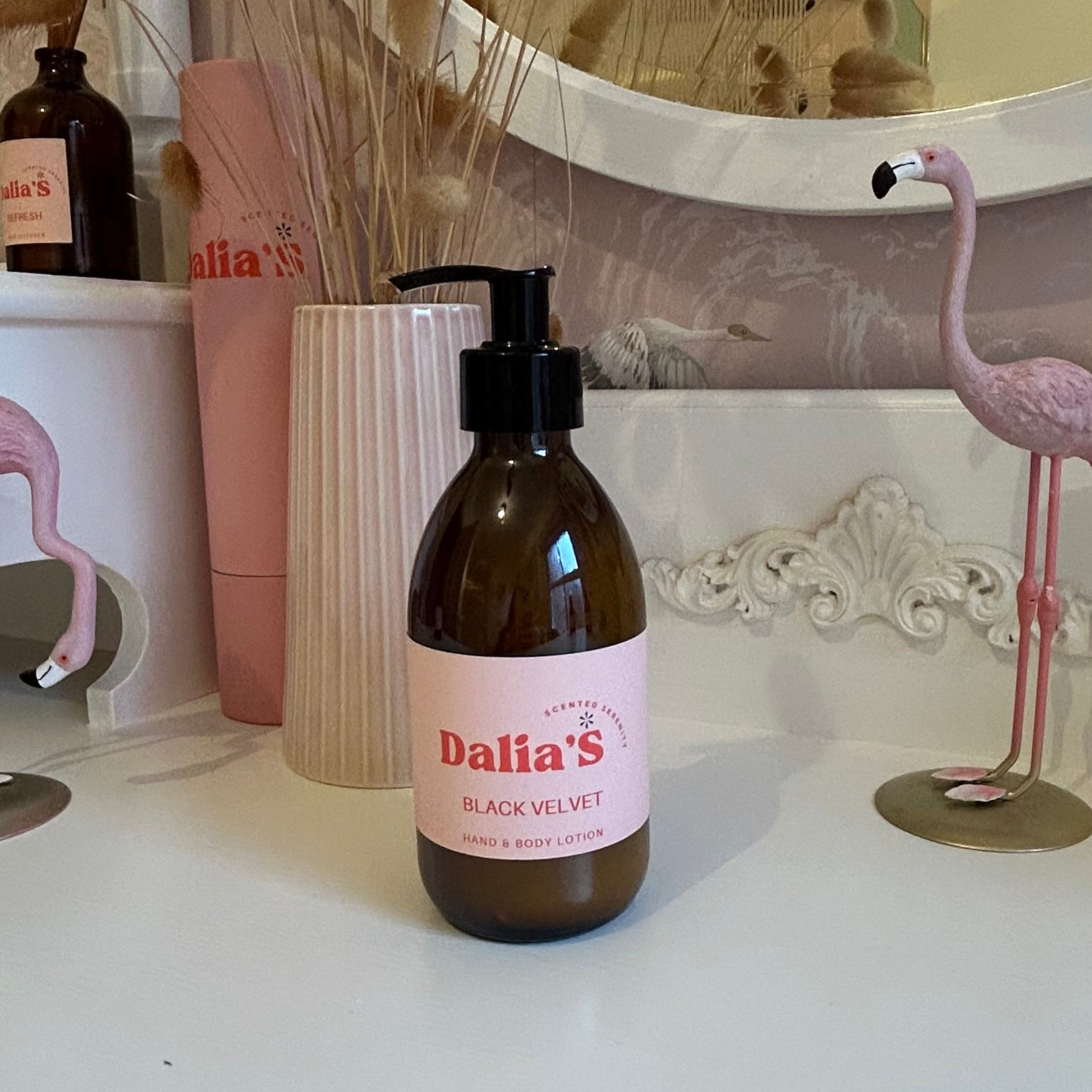 A 250ml brown glass bottle of Black Velvet hand and body lotion with a pump dispenser, labeled with the brand name and product description.