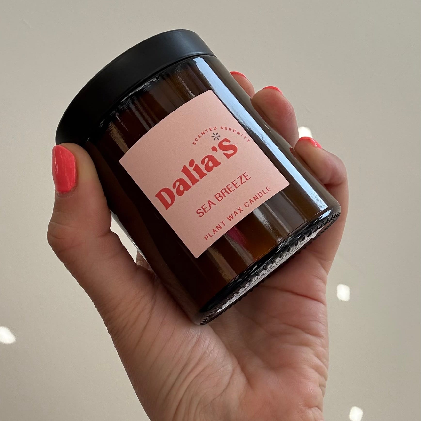 Hand holding a jar labeled 'Dalia's' against a neutral background